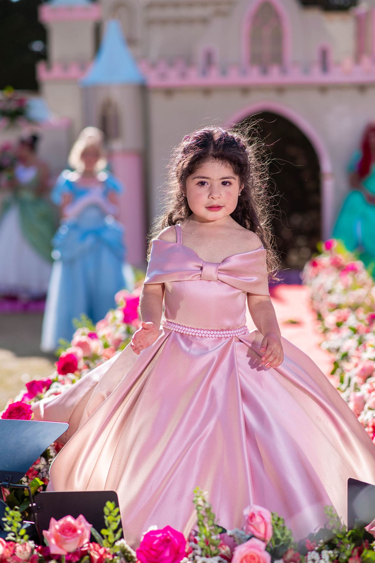 Niña con vestido malva satinado de escote off-shoulder y lazo al frente