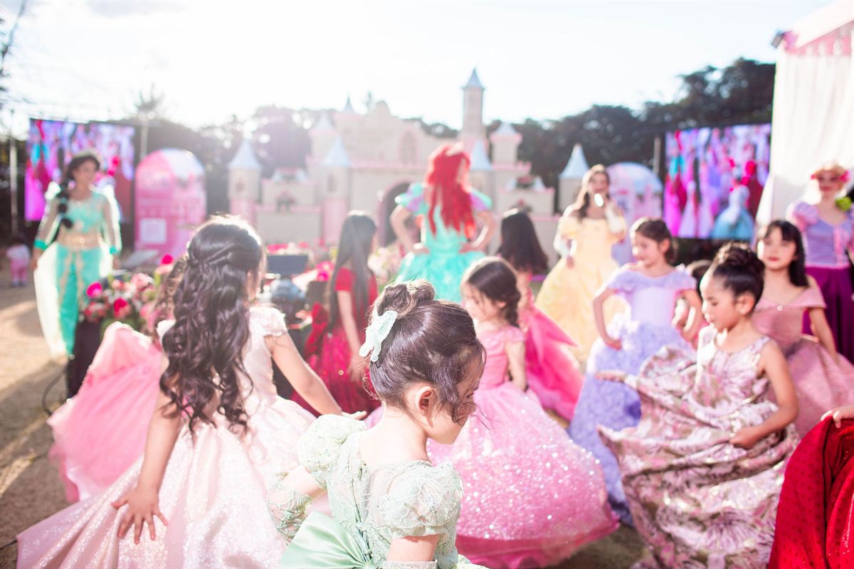 Niñas con vestidos de colores giran en la pasarela, a contraluz